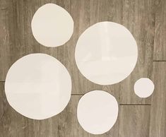 three white circles sitting on top of a wooden floor