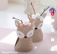 two little deer figurines sitting next to each other on top of a table