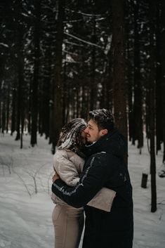 a man and woman hugging in the snow