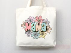 a white bag with flowers and the word bmb on it is hanging from a wall