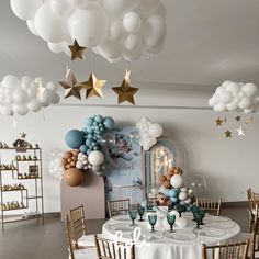 a table set up for a party with balloons and stars