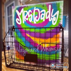 a metal basket with the word mega daddy painted on it, sitting on a table