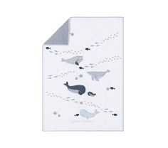 a white blanket with whales and stars on the bottom, in front of a white background