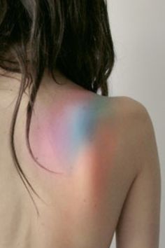 the back of a woman's body is painted multicolored