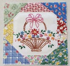 a piece of fabric with flowers and a basket on it's side, all in different colors