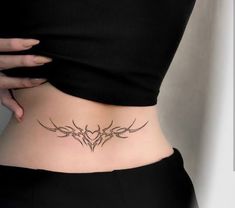 a woman's stomach with an intricate tattoo design on her lower back and side