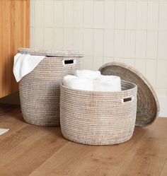 two wicker baskets with towels in them on the floor