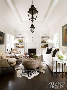 a living room filled with furniture and a fire place in front of a white wall