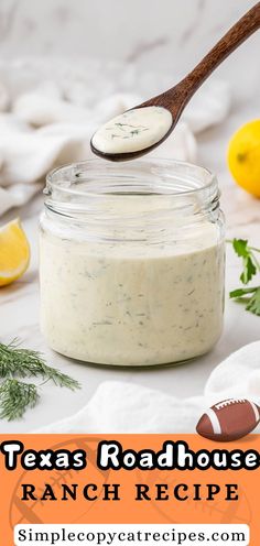 a mason jar filled with ranch dressing next to a football and lemons