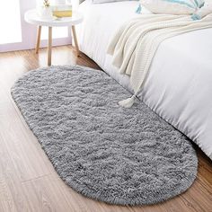 a large gray rug on the floor next to a bed