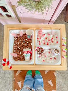 a person standing in front of a tray with food and candy on top of it