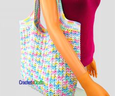 a mannequin holding a crocheted handbag in front of a white background