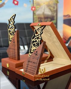 two wooden boxes with designs on them sitting on a table