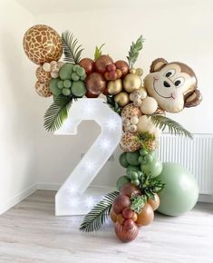 the number two is decorated with balloons and jungle animals