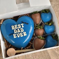 a blue heart shaped box filled with chocolate strawberries