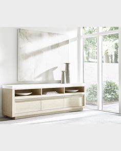 a large white tv stand in front of a window