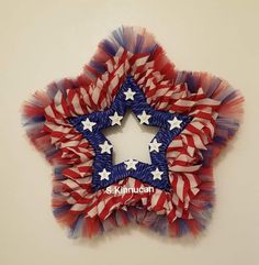 a red, white and blue star shaped decoration with stars on the center is shown