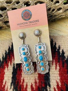 New without tags BRAND : Nizhoni Traders LLC ETHNIC & REGIONAL STYLE : Native American JEWELRY TYPE : Earrings METAL : Sterling Silver TRIBAL AFFILIATION : Navajo MAIN STONE : Turquoise Lovely Navajo Turquoise and Sterling Silver dangle earrings. Measure 2 7/8 inches long and 3/4 of an inch wide. Great pair of earrings! Stamped Sterling and signed by the artist. Thank you for checking out my store. Please contact me with any questions. Exported By exportyourstore.com Southwestern Style Blue Pierced Earrings, Southwestern Style Blue Earrings For Pierced Ears, Southwestern Blue Earrings For Pierced Ears, Southwestern Blue Earrings For Gift, Blue Southwestern Style Earrings For Gift, Artisan Blue Drop Earrings, Southwestern Style Blue Drop Earrings, Southwestern Blue Drop Earrings, Nickel-free Blue Southwestern Earrings