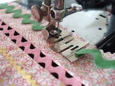 the sewing machine is on top of the table with pink and green trimmings