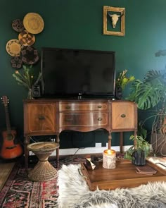 a living room filled with furniture and a flat screen tv on top of a wooden table