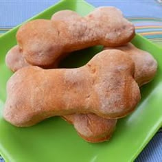 two dogs bone shaped pastries on a green plate