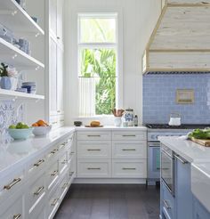 a kitchen with white cabinets and blue tile backsplashes on the countertops