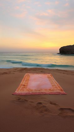 a blanket laying on top of a sandy beach