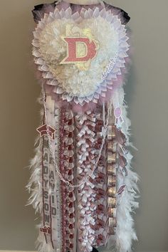 a dress made out of feathers and beads with the letter d on it's back