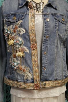 a woman's jean jacket with floral appliques on the front and back