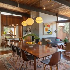 a dining room table with chairs and a bowl of fruit on top of the table