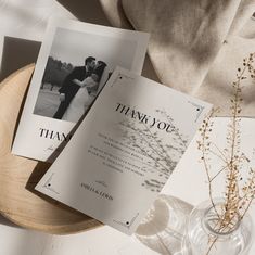 two wedding thank cards sitting on top of a wooden plate