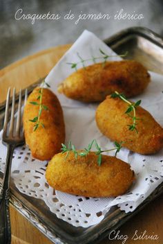 four fried food items on a plate with a fork