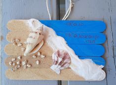 a wooden sign with sea shells on it