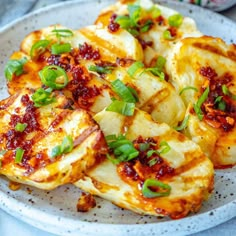 some food is on a white plate with green garnishes and sauces