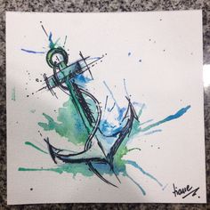 an anchor painted in watercolor on white paper with blue and green paint splatters