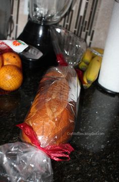 there are some fruit on the counter next to a blender and bagged bread