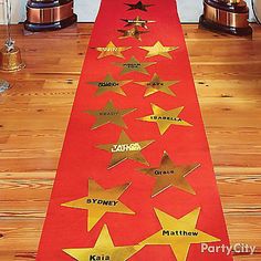 a red table runner with gold stars on it and two trophies in the back ground