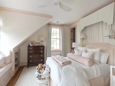 a bedroom with white bedding and pink accents