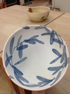 a blue and white bowl sitting on top of a wooden table