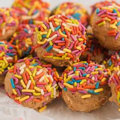 chocolate donuts with sprinkles and colored frosting on white wrapper