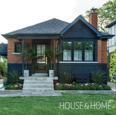 a house that is painted blue and has flowers in the front yard, along with steps leading up to it