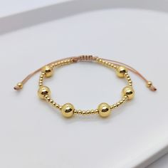 Elegant Gold Friendship Bracelets With Gold Beads, Gold Braided Bracelet With Adjustable Length, Adjustable Yellow Gold Metal Beaded Bracelets, Gold Friendship Bracelets With Gold Beads, Adjustable Gold Beaded Metal Bracelets, Gold Beaded Bracelets With Adjustable Length, Adjustable Gold-tone Metal Beaded Bracelet, Rose Gold Metal Bracelets With Round Beads, Rose Gold Metal Bracelet With Round Beads