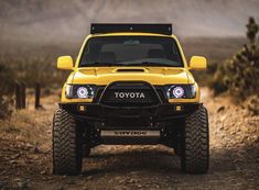 the front end of a yellow toyota truck