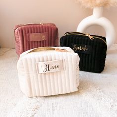 three small purses sitting next to each other on a white tableclothed surface