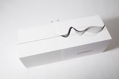 a white box with wavy lines on the front and side, sitting on a plain surface