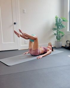 a woman is doing yoga on a mat in front of a window with her legs spread out