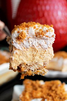 a piece of cake is being held up to show the cream cheese filling on it