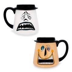 two coffee mugs with faces painted on them, one black and the other white