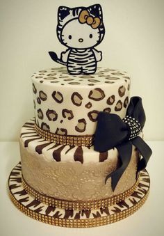 a three tiered cake decorated with an image of a hello kitty sitting on top