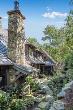 a stone house surrounded by greenery and trees